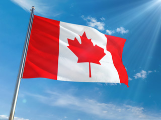 Canada National Flag Waving on pole against sunny blue sky background. High Definition