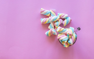 cup with colorful marshmallows, pink background