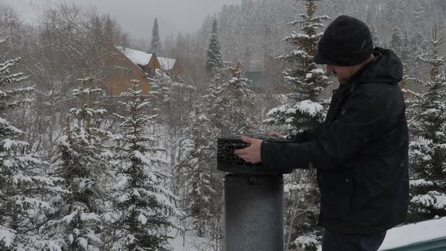 Man finished cleaning chimney on the roof.