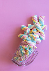cup with colorful marshmallows, pink background