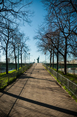 Fototapeta na wymiar Camino en París con fondo de la estatua de la libertad replica