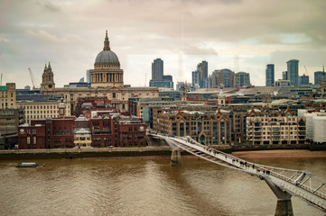 Fototapeta na wymiar The millennium bridge in london uk on thames river and buildings across