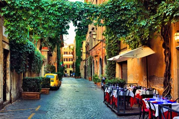 Foto op Plexiglas Mooie oude straat in Rome omzoomd met lommerrijke wijnstokken en cafétafels, Italië © Jenifoto