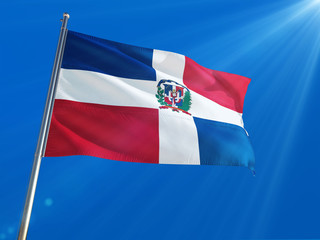 Dominican Republic National Flag Waving on pole against deep blue sky background. High Definition