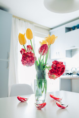 Modern kitchen design. Interior of white and silver kitchen decorated with flowers. Cozy apartment