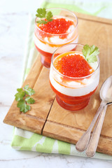 Two verrines of appetizer. Grilled red bell pepper mousse, cream cheese and red caviar