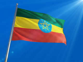 Ethiopia National Flag Waving on pole against deep blue sky background. High Definition