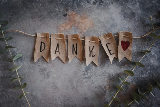 Wimpelkette mit den Buchstaben Danke; Postkarte mit Eukalyptuszweigen