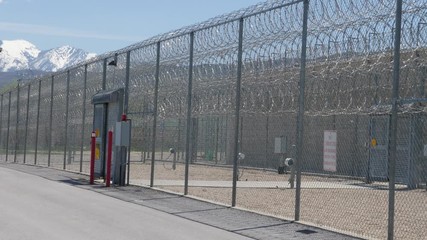 Prison front gate with lots or barbed wire.
