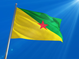 French Guiana National Flag Waving on pole against deep blue sky background. High Definition
