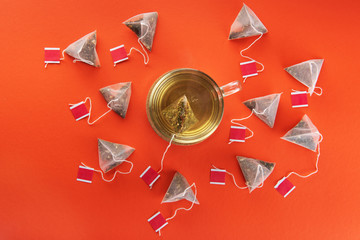 Pyramid tea bags. Geometric shape on orange background. Tea.