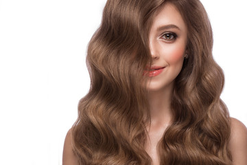 Fototapeta premium Beautiful brown-haired girl with a perfectly curls hair, and classic make-up. Beauty face and hair.