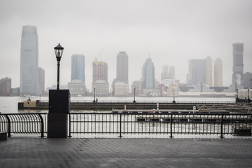 Hudson river docks under the rain overlooking the skyline from the heart of Wall Street in Manhattan - New York City, NY