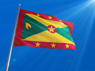 Grenada National Flag Waving on pole against deep blue sky background. High Definition