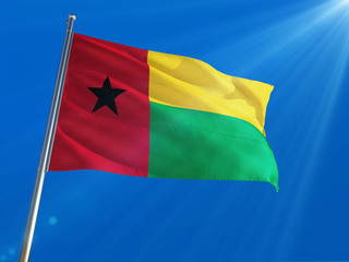 Guinea Bissau National Flag Waving on pole against deep blue sky background. High Definition