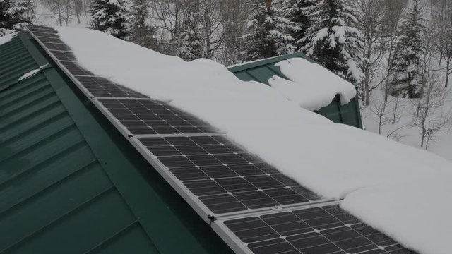 Row of snow covered solar panels during a storm