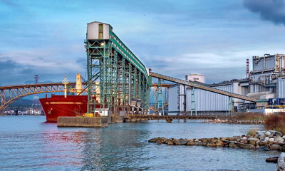 Ship under loading in sea port of  Vancouver  port on the background of cloudy sky
