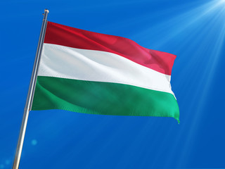 Fototapeta na wymiar Hungary National Flag Waving on pole against deep blue sky background. High Definition