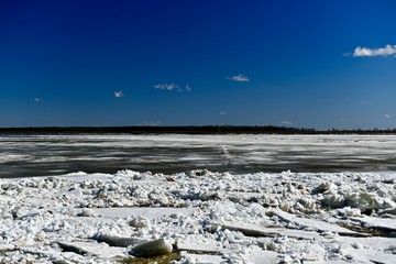 Blue sky and the beginning of the movement of ice on the river in the spring.
