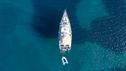 Aerial drone bird's eye top view photo of luxury yacht with wooden deck docked in deep blue waters...