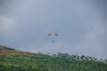 Fototapeta na wymiar Paragliding athletes while competing in the national championship, flying from a Sikuping hill in Batang Central Java