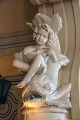 Fototapeta premium generic putti or cherub riding a dolphin. Traditional Italian renaissance style architectural ornament.