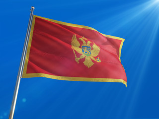 Montenegro National Flag Waving on pole against deep blue sky background. High Definition