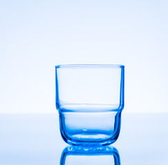 Clear drinking glass on  blue background