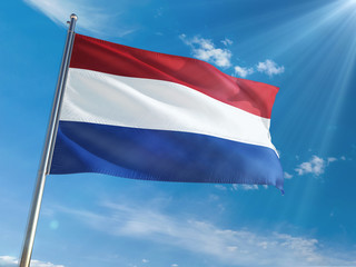 Netherlands National Flag Waving on pole against sunny blue sky background. High Definition