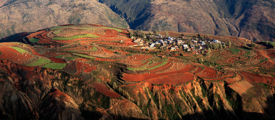 Dongchuan Red Earth Multi-Colored Terraces - Red Soil, Green Grass, Layered Terraces in Yunnan Province, China. Chinese Countryside, Agriculture, Exotic Unique Landscape. Farmland, Agriculture