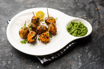 Tandoori aloo are roasted potatoes with Indian spices. It's a party appetiser served with green chutney. selective focus