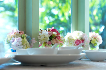 Flowers for decorating in weddings, elegantly arranged on the dining table by the window, beautiful natural light