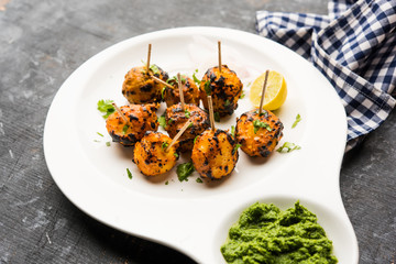 Tandoori aloo are roasted potatoes with Indian spices. It's a party appetiser served with green chutney. selective focus