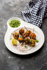 Tandoori aloo are roasted potatoes with Indian spices. It's a party appetiser served with green chutney. selective focus