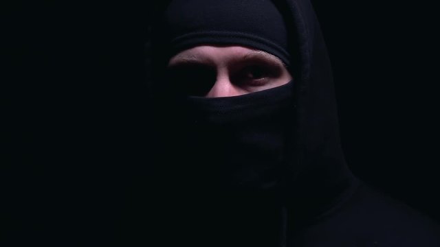 Hooded male in balaclava looking at camera, ready for illegal action, crime