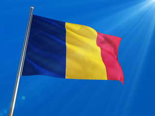 Romania National Flag Waving on pole against deep blue sky background. High Definition