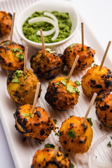 Tandoori aloo are roasted potatoes with Indian spices. It's a party appetiser served with green chutney. selective focus