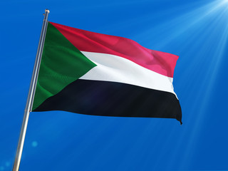 Fototapeta na wymiar Sudan National Flag Waving on pole against deep blue sky background. High Definition