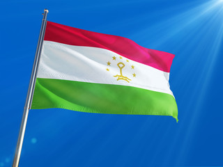 Tajikistan National Flag Waving on pole against deep blue sky background. High Definition