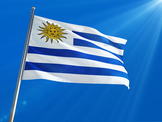 Uruguay National Flag Waving on pole against deep blue sky background. High Definition