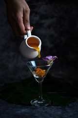 Pour fresh orange juice into a glass with ice.