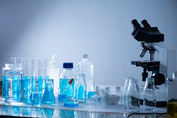microscope with lab glassware, science laboratory research and development concept