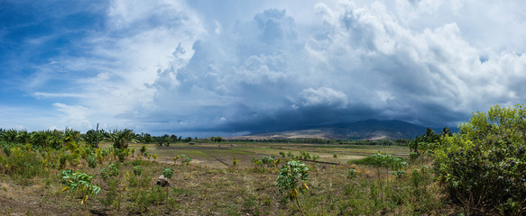Scenic landscape Picture of land and mountain on the deep village in Flores islands during the cloudy and windy day with cumulus cloud developing in to cumulonimbus cloud. Beautiful Indonesian nature