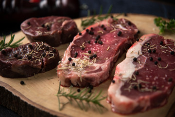 raw beef steak on wooden cutting board