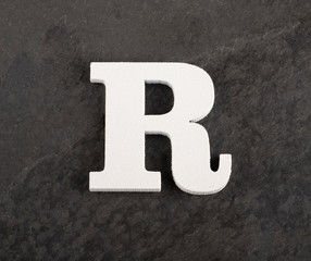Letter R from blank alphabet on gray background - Top view