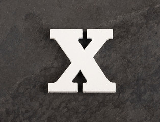 Letter X from blank alphabet on gray background - Top view