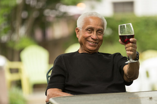 Black man with wine glass outside