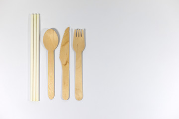 Bamboo cutlery and paper straws isolated on white background, alternative to single use plastics, zero waste, sustainable lifestyle