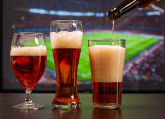 Beer glasses in front of tv, football at home