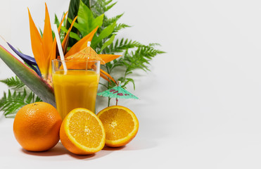 Glass of orange juice with cut and whole orange, paper straw, tropical theme, vitamin C boost, healthy choices